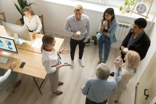 A group of millennial workers stand at work